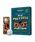 TaylorMade TP5 Pretzels-emballagekasse i mørk blågrøn med gulddetaljer, vist sammen med et mindre billede af kassen set fra siden og to hvide Golfbolde med produktlogoet trykt på en ensfarvet hvid baggrund.